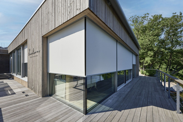 Witte buitenscreens van VABO als zonwering bij moderne houten gevel