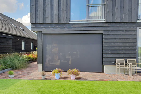 Donkere buitenscreens van VABO bij garage en moderne gevelbekleding
